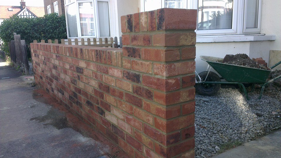 Bricklayer laying a course of bricks